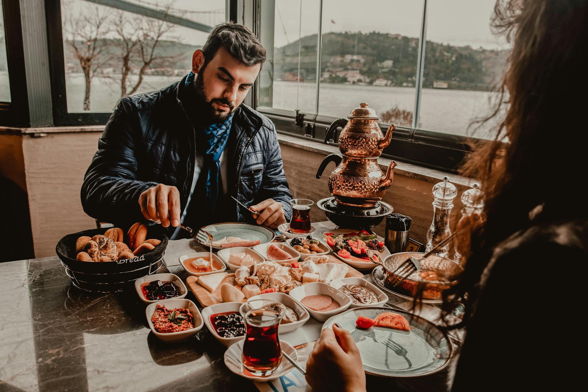 Paar genießt üppiges türkisches Kahvaltı mit Blick auf den Bosporus in Istanbul.