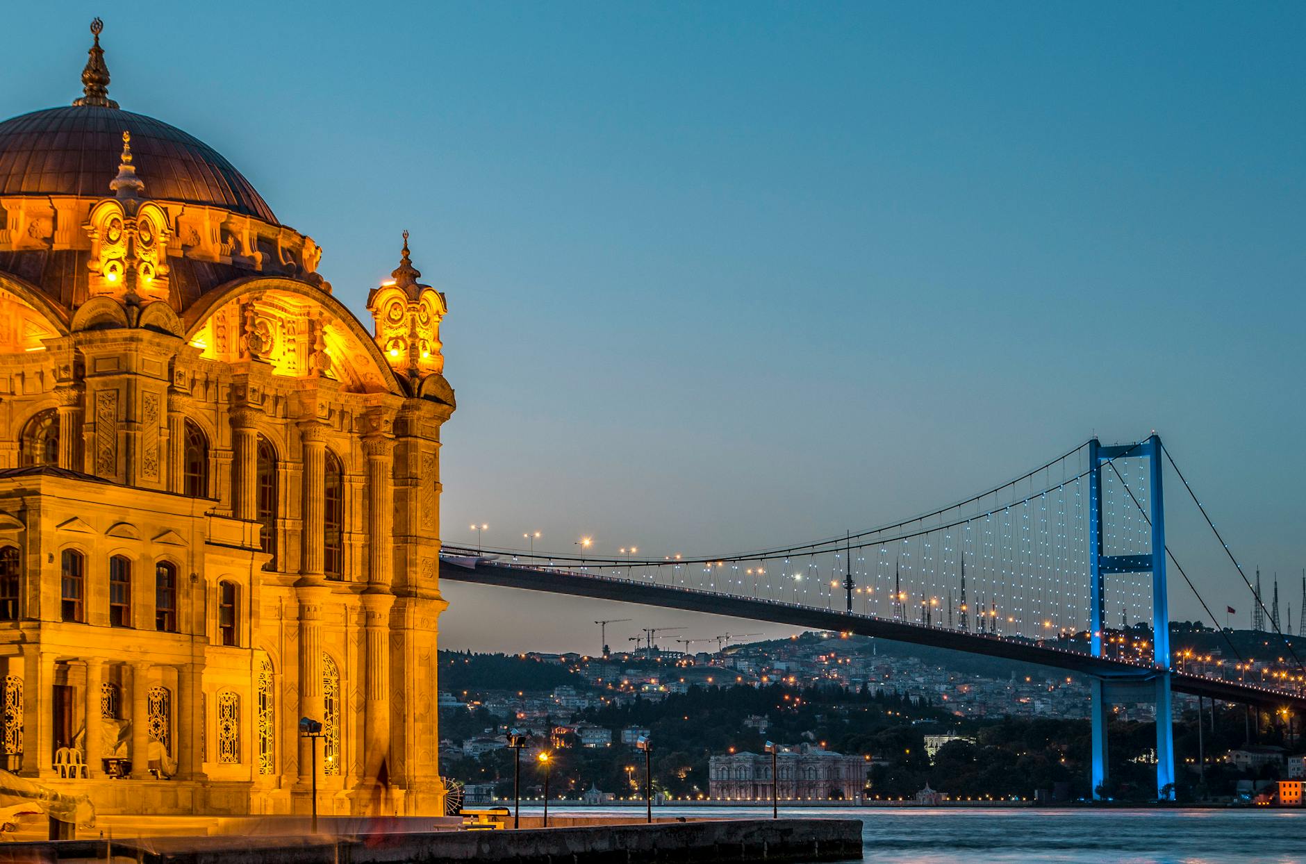 Die beleuchtete Ortaköy-Moschee und die Bosporus-Brücke in der blauen Stunde.