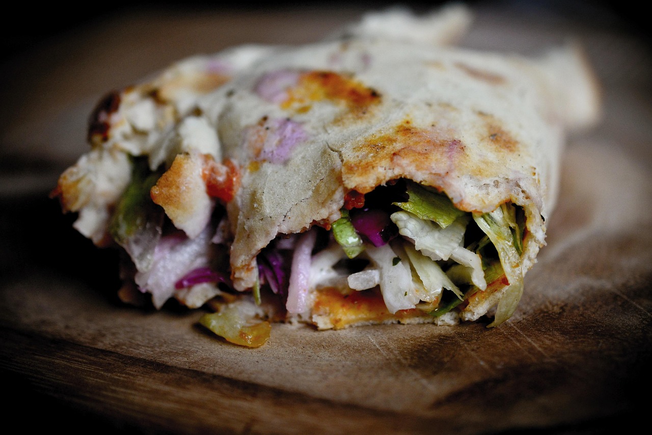 Ein knusprig gerolltes Lahmacun gefüllt mit frischem Salat und Zwiebeln im Detail.