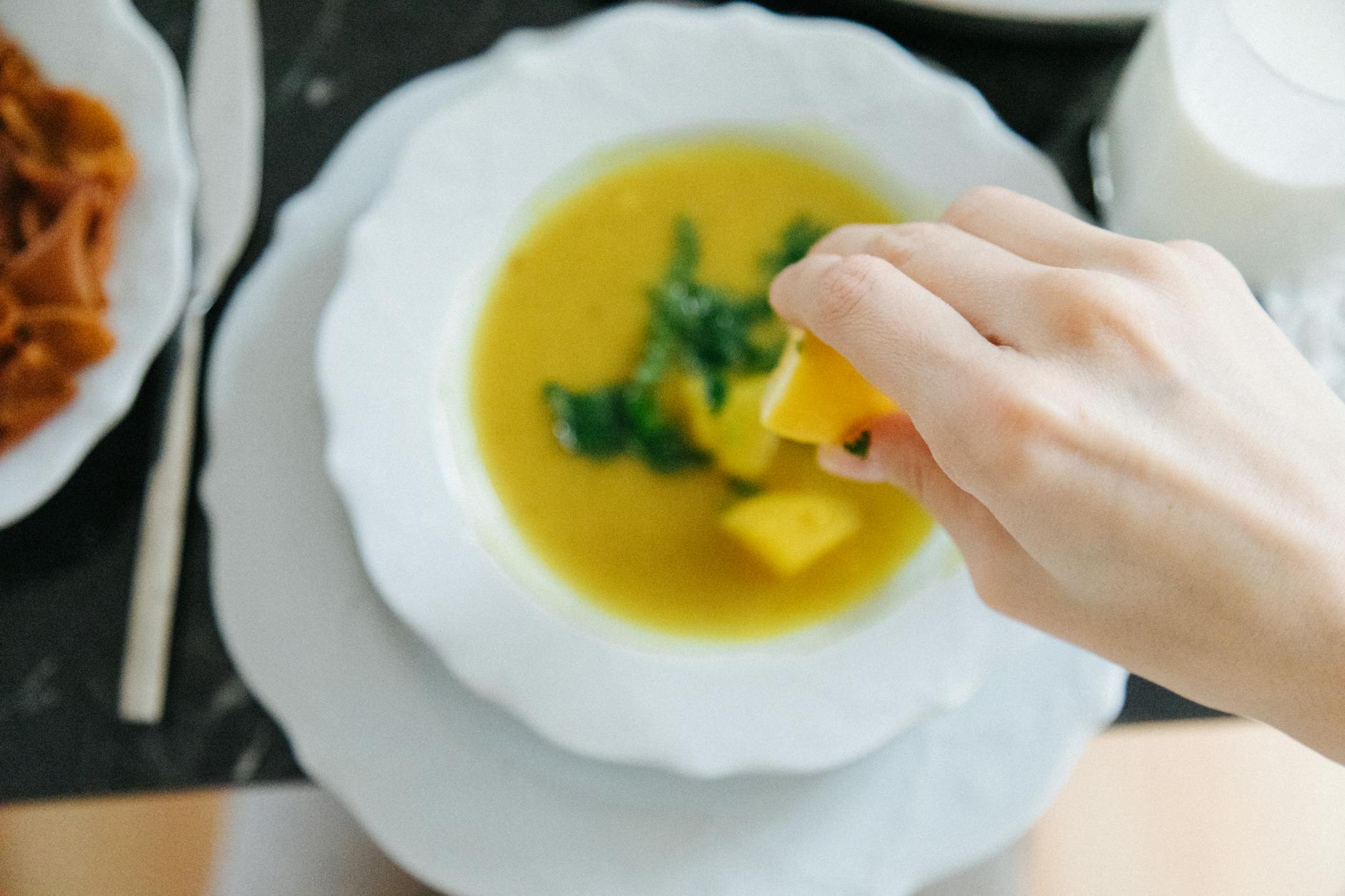 Traditionelle türkische Linsensuppe wird in einer weißen Schüssel mit Zitrone serviert.